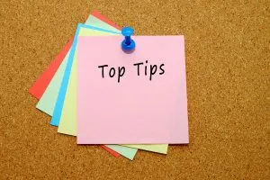 Five coloured sticky notes pinned to a corkboard and the top note reads 'Top tips'.