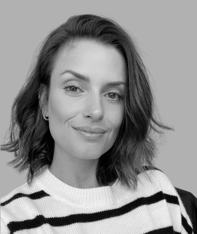 Smiling headshot of Juliana Ribeiro, Plain English Foundation's Marketing Manager. She's wearing a black and white striped shirt.